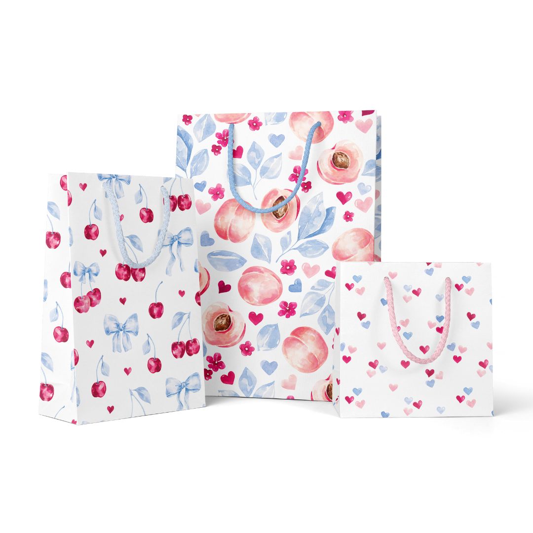 Three decorative paper gift bags with floral and fruit patterns on a white background