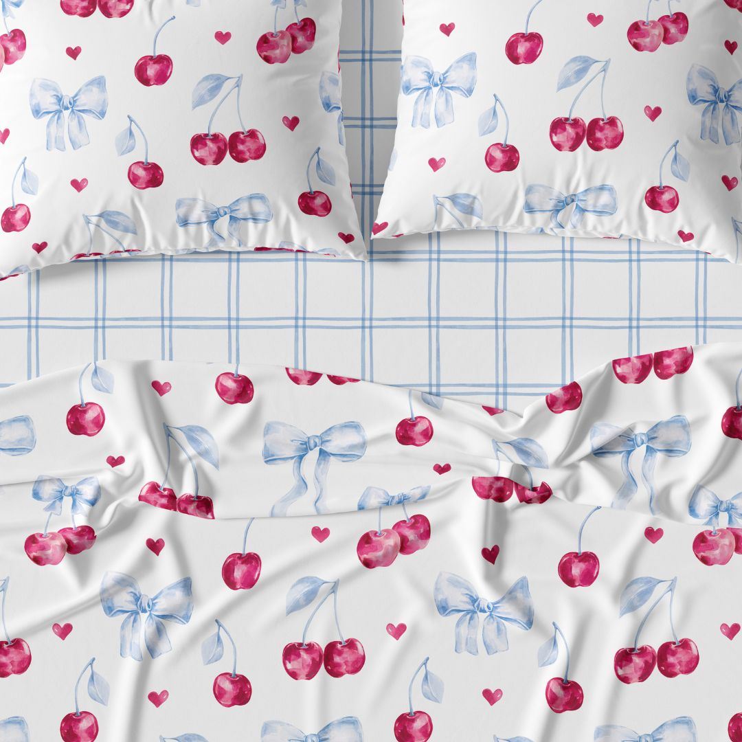 Sheet set with cherry and bow pattern and plaid patterns.