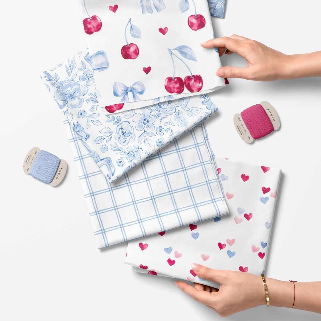 Fabric samples with various patterns held by hands on a light background